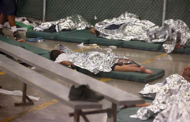 Young boys sleep in a holding cell.