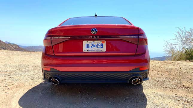 A rear shot of the Jetta GLI parked on dirt in front of mountains