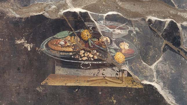 The still life fresco of a food platter, with mensa flatbread at left.