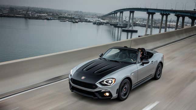 A silver 2020 Fiat 124 Spider Abarth driving across a bridge over water