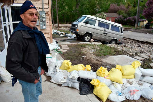 Ken Ebel is seen in front of his flood-damaged house and yard, Tuesday, June 14, 2022, in Red Lodge, Mont.
