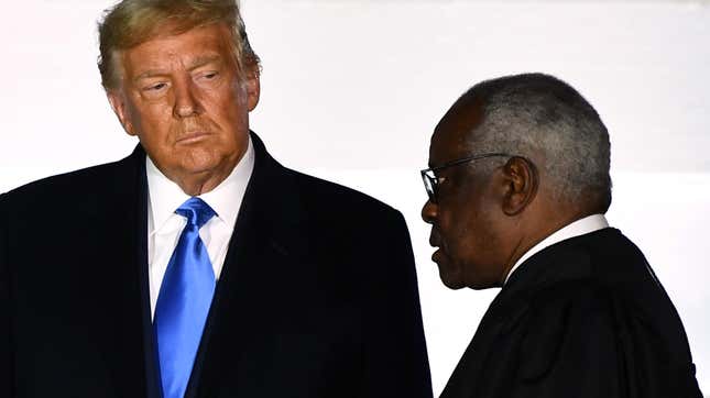 Le président américain Donald Trump regarde le juge associé de la Cour suprême Clarence Thomas prêter serment à la juge Amy Coney Barrett (hors cadre) en tant que juge associée de la Cour suprême des États-Unis lors d’une cérémonie sur la pelouse sud de la Maison-Blanche, le 26 octobre 2020, à Washington, DC.