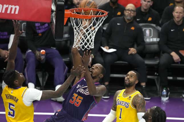 Nov 10, 2023; Phoenix, Arizona, USA; Phoenix Suns forward Kevin Durant (35) scores between Los Angeles Lakers forward Cam Reddish (5) and guard D&#39;Angelo Russell (1) in the first half at Footprint Center.