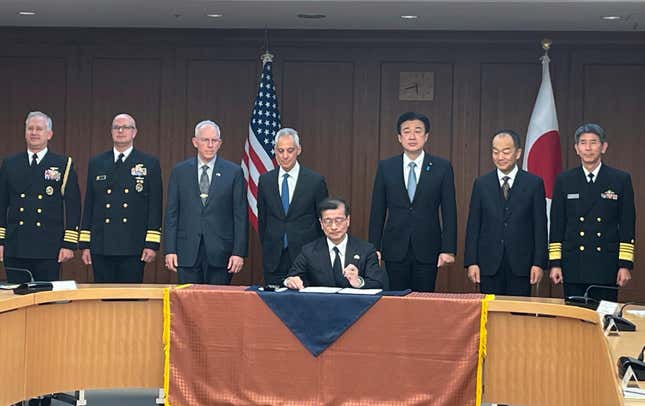 Japanese and U.S. military officials and U.S. Ambassador to Japan Rahm Emanuel, fourth left, and Japanese Defense Minister Minoru Kihara, third right, stand behind a defense equipment procurement official as he signs a document for the Tomahawk purchase deal at the Japanese Defense Ministry, in Tokyo, Thursday, Jan. 18, 2023. Japan has signed a deal with the United States to purchase up to 400 Tomahawk cruise missiles as part of its ongoing military buildup in response to increased regional threats. U.S. Ambassador to Japan Rahm Emanuel attended a signing event at Japan&#39;s Defense Ministry on Thursday. (AP Photo/Mari Yamaguchi)