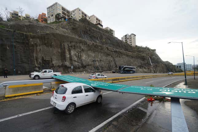 A traffic sign lays on a car after Hurricane Otis ripped through Acapulco, Mexico, Wednesday, Oct. 25, 2023. Hurricane Otis ripped through Mexico&#39;s southern Pacific coast as a powerful Category 5 storm, unleashing massive flooding, ravaging roads and leaving large swaths of the southwestern state of Guerrero without power or cellphone service. (AP Photo/Marco Ugarte)