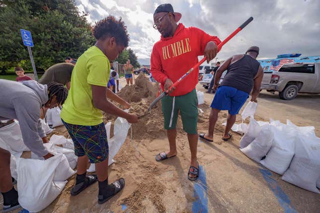 Jawan Williams shovels sand for a sandbag held by his son Jayden Williams, before landfall of Hurricane Ida at the Frederick Sigur Civic Center in Chalmette, La., which is part of the Greater New Orleans metropolitan area, Saturday, Aug. 28, 2021. Hurricane Ida looks an awful lot like Hurricane Katrina, bearing down on the same part of Louisiana on the same calendar date. But hurricane experts say there are differences in the two storms 16 years apart that may prove key and may make Ida nastier in some ways but less dangerous in others