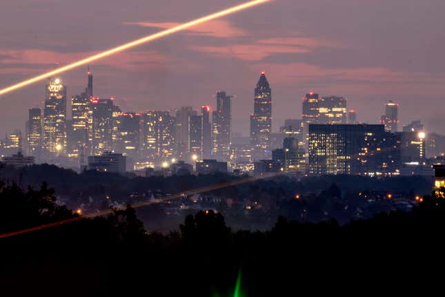 The buildings of the banking district are pictured in Frankfurt, Germany, early Wednesday, Oct. 11, 2023. Light strips are caused by vehicles driving by. (AP Photo/Michael Probst)