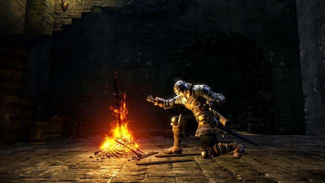 A screenshot of Dark Souls Remastered showing the Chosen Undead kneeling by a restorative bonfire in the dark.