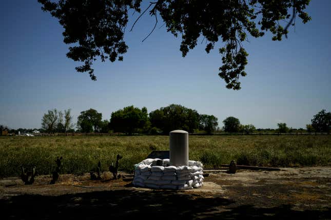 FILE - Sandbags are stacked around a well in anticipation of flooding of the Kings River in the Island District of Lemoore, Calif., April 19, 2023. California officials are considering whether to take over monitoring groundwater use in the fertile San Joaquin Valley under a landmark law aimed at protecting water flow to homes and farms. The Tuesday, April 16, 2024, hearing before the State Water Resources Control Board is the first of its kind since California passed a groundwater management law a decade ago. (AP Photo/Jae C. Hong, File)