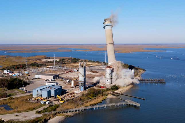 The smokestack at the former B.L. England Generating Station, a coal and oil burning power plant in Upper Township, N.J., is toppled during a control demolition on Thursday, October 26, 2023. The site will be redeveloped as a mixed-use residential and commercial project, and a nearby electrical substation will be used to connect New Jersey&#39;s soon-to-come offshore wind farms with the electrical grid. (AP Photo/Ted Shaffrey)