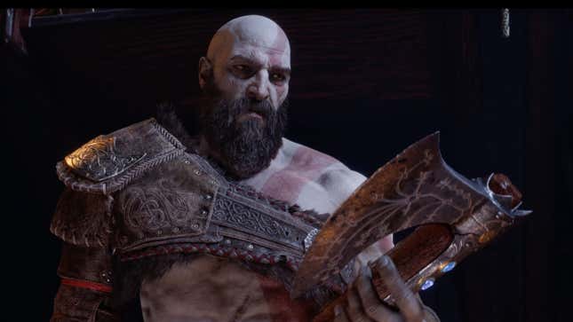 Kratos stares sadly at the axe he holds in his hands.