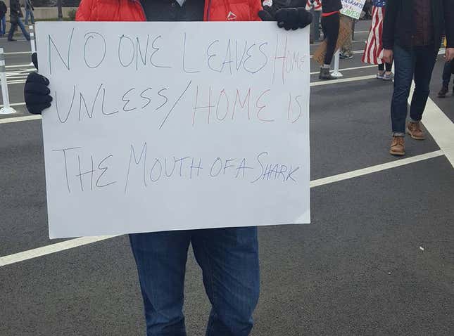 Protesters in DC hold signs quoting the poem “Home,” by Warsan Shire.