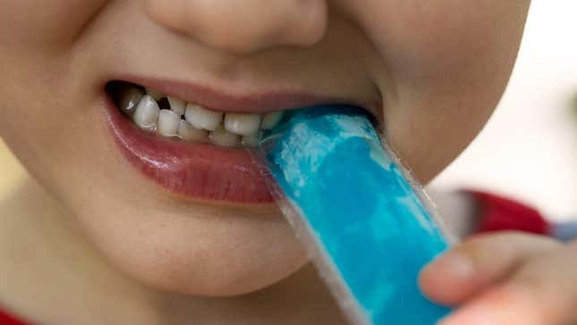 Child biting into blue freeze pop