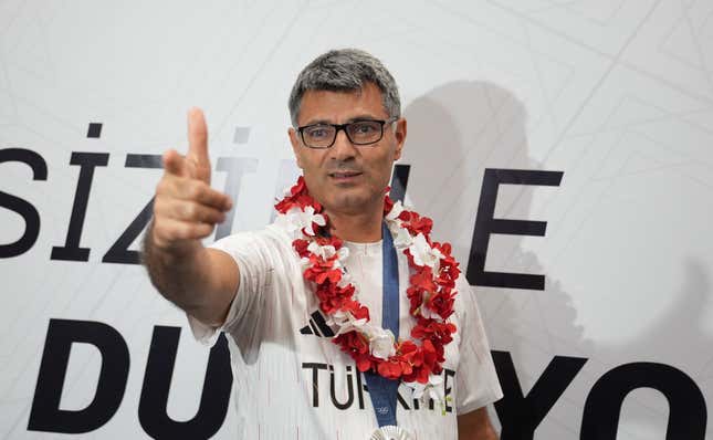 Yusuf Dikeç throwing up fingers guns at the 2024 Olympics after taking home the silver medal. 