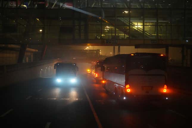 Buses carrying international passengers depart for hotels under escort at Beijing Capital International Airport on January 24, 2022 in Beijing, China. 