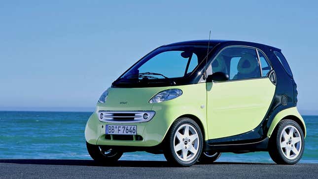 A photo of a mint green Smart car. 