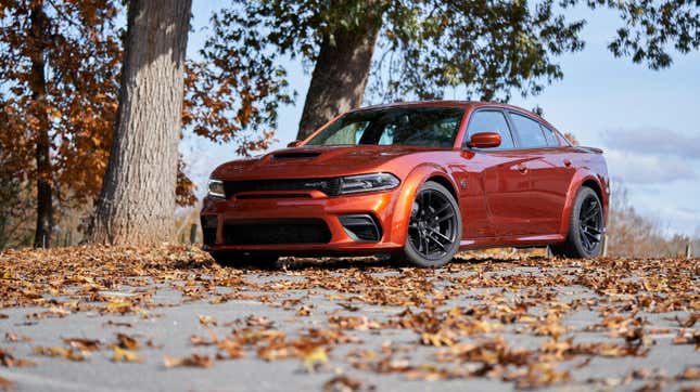 Une Dodge Charger SRT Hellcat Redeye 2023 garée dans un terrain couvert de feuilles mortes