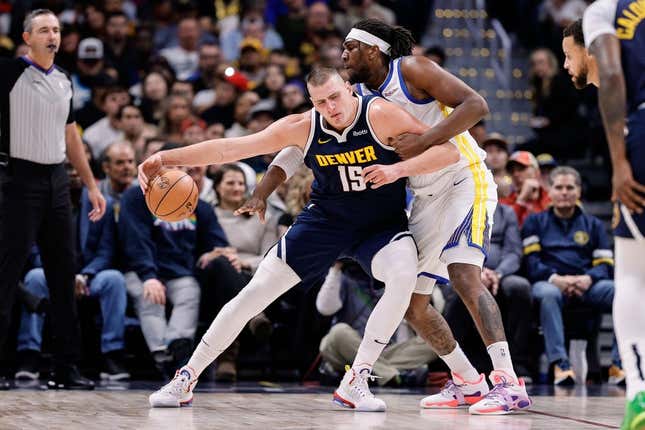 Nov 8, 2023; Denver, Colorado, USA; Denver Nuggets center Nikola Jokic (15) controls the ball under pressure from Golden State Warriors forward Kevon Looney (5) in the first quarter at Ball Arena.