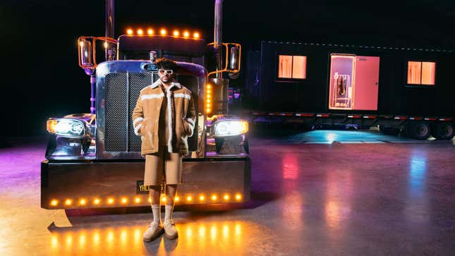 Singer Bad Bunny poses in front of his black big rig.