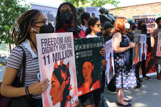 People hold up signs as they gather for a rally to celebrate the 10th anniversary of the Deferred Action for Childhood Arrivals (DACA) in Battery Park on June 15, 2022 in New York City