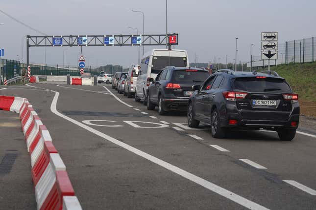 FILE - Cars queue towards Poland at the Krakovets - Korcheva border crossing point in Krakovets, Ukraine, Tuesday, Aug. 16, 2022. Poland has begun enforcing an entry ban on all Russian-registered passenger cars seeking to enter the country. The move comes just days after the nearby Baltic states of Lithuania, Latvia and Estonia banned vehicles with Russian license plates from entering their territory. (AP Photo/Roman Baluk, File)