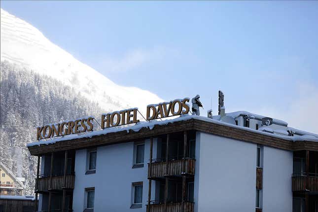 An armed member of the Swiss Police watches from the roof of the Hotel Davos ahead of the WEF.