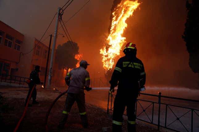 Firefighters and soldiers try to extinguish flames.