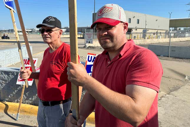 Striking United Auto Workers member Chris Jedrzejek, right, and his father picket outside Ford Motor Co.&#39;s Michigan Assembly Plant Monday, Oct. 2, 2023, in Wayne, Mich. (AP Photo/Mike Householder)