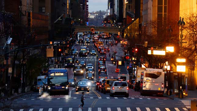 A person runs across 42nd Steet as the sun rises in New York.