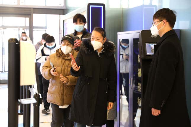 Customers scan their health codes at the entrance of a shopping mall as  Beijing no longer requires people to show their negative nucleic acid  testing results before entering public places on December 6, 2022 in  Beijing, China.