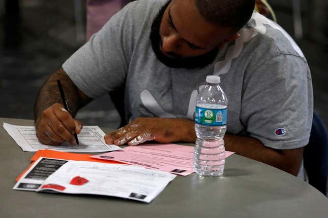 A man fills out a form during an event held by the Florida Rights Restoration Coalition (FRRC) to clear the fines and fees of dozens of Florida residents with past felony convictions, in Miami, Florida, on April 28, 2022. - Hundreds of thousands of returning citizens (people with past felony convictions) in Florida still owe fines and fees associated with their past convictions. These financial obligations create barriers to voting, accessing opportunities, getting driver’s licenses, and more.