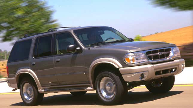 A photo of a gray Ford Explorer SUV driving on a highway. 