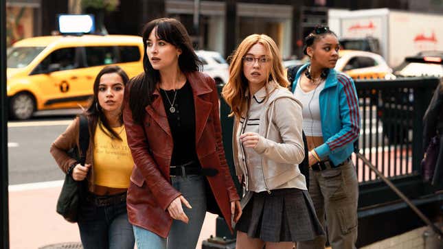 Four women stand on a New York City sidewalk outside a subway station in Madame Web