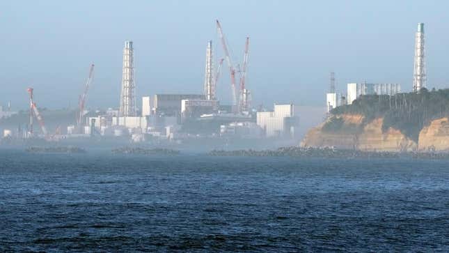 A Japanese fishing port with the Fukushima Daiichi nuclear power plant in the background