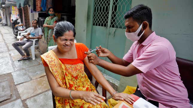 A woman reacts as she receives a dose of the COVISHIELD vaccine in Ahmedabad, India.