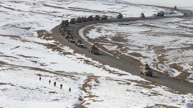 Des soldats débarqués du 1er peloton de la 216e compagnie d’augmentation mobile de la Garde nationale de l’armée américaine de Long Beach, en Californie, marchent le long de l’autoroute 1 à la recherche de tout signe d’engins explosifs improvisés installés tandis que leurs véhicules blindés surveillent la route lors d’une mission le 22 janvier.