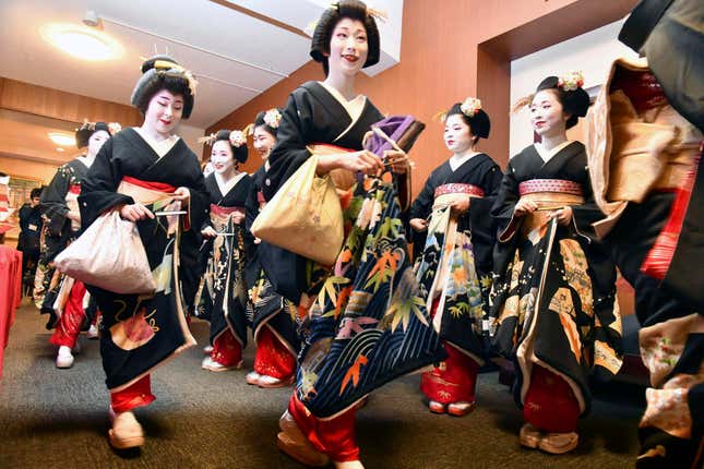 FILE - Kimono-clad &quot;geiko&quot; and &quot;maiko&quot; professional entertainers arrive for a ceremony to start this year&#39;s business in Kyoto, western Japan, on Jan. 7, 2020. Japan’s ancient capital of Kyoto, long a popular destination for tourists, will be closing off some private-property alleys in its famous geisha district, as complaints grow about misbehaving visitors. (Kyodo News via AP, File)