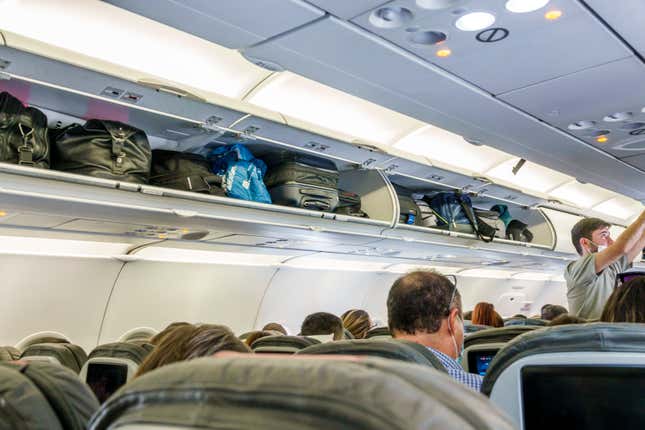 Bogota, Colombia, El Dorado International Airport, American Airlines flight economy cabin, filled full overhead luggage compartment and passengers 