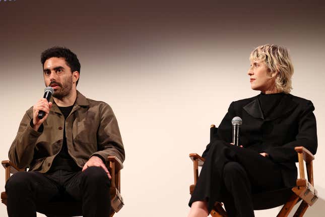 Cristobal Valenzuela and Claire L. Evans sitting in directors chairs next to each other speaking with microphones in front of an off white backdrop