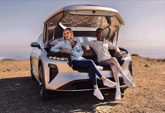 Two women sit in the front truck of a Lucid Gravity electric SUV in silver