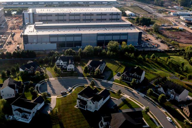 aerial view of AWS data center behind a row of houses around a road with a cul de sac at the end