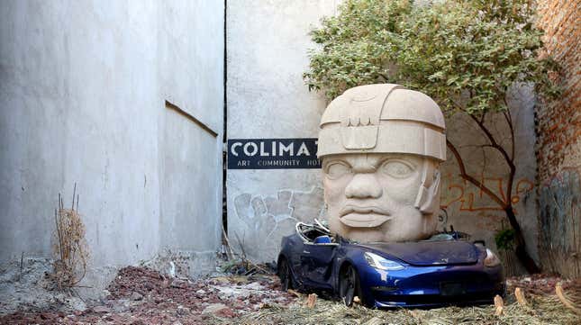 An art installation of Mexican artist Chavis Marmol where a Tesla 3 car is crushed by a nine-ton Olmec-inspired head is pictured at Colima71 Art Community Hotel on March 20, 2024 in Mexico City, Mexico.