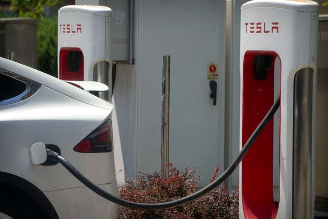 FILE - A vehicle charges at an electric vehicle station outside of a Tesla dealership in Beijing, June 24, 2023. Amid an ongoing push to make transportation less damaging to the climate, electrification continued to accelerate in 2023, with one in five cars sold across the globe this year expected to be electric, according to the International Energy Industry. (AP Photo/Mark Schiefelbein, File)