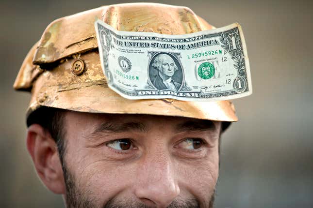 FILE - A man wears a one dollar bill on a miner&#39;s helmet painted in gold color in Bucharest, Romania, Sept. 21, 2013, during a protest against the exploitation of gold by by Gabriel Resources, a Canadian mining company, at Rosia Montana, the site of ancient Roman mining galleries in a mountainous western Romanian region and home to Europe&#39;s largest gold deposits. The Romanian government has won a years-long legal dispute with a Canadian mining company seeking financial damages over failed plans to open a gold and silver mine in the Eastern European country. (AP Photo/Vadim Ghirda, File)