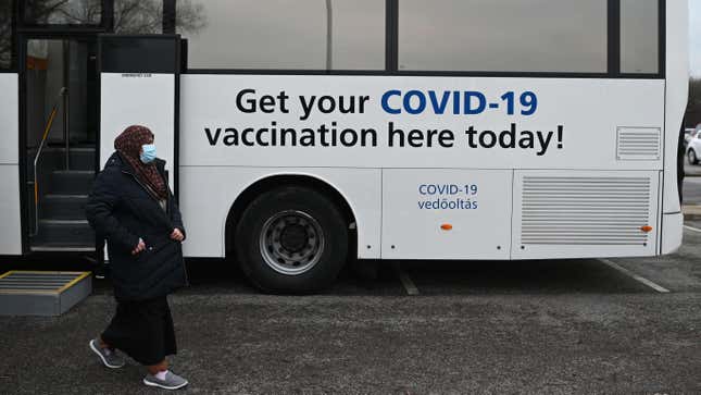 People receiving their covid-19 vaccine or booster at a NHS (National Health Service) bus outside an Asda Supermarket in the town of Farnworth, near Manchester in north-west England on December 20, 2021.