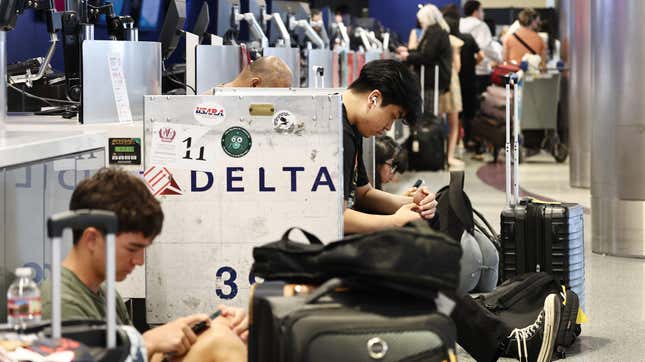 Les passagers attendent au bureau d’enregistrement de Delta Air Lines