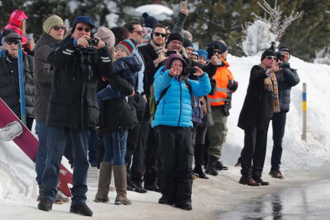 People react as a helicopter carrying US president Donald Trump lands in Davos on Jan. 25.