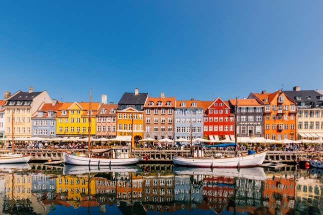 Casas de colores vibrantes a lo largo del puerto de Nyhavn en un día soleado con un cielo azul claro