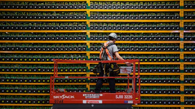 A technician inspects the backside of bitcoin mining operation.