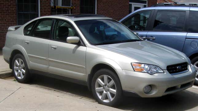 a light gold third-generation SUbaru Outback Sedan parked in a parking lot